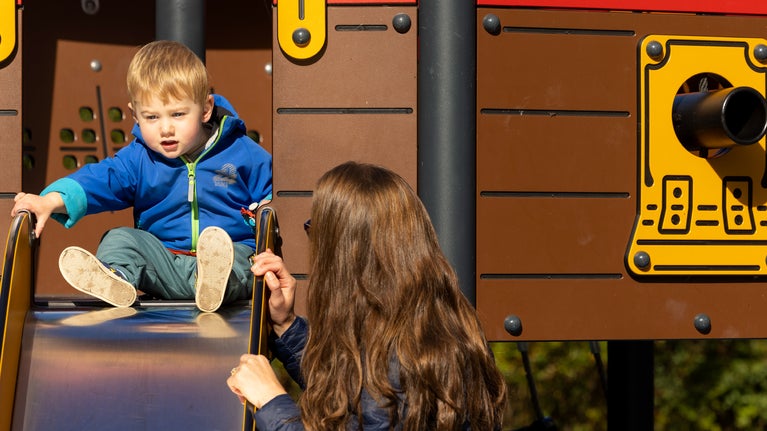 Family visitors playing on a slide, Foremark, Derbyshire